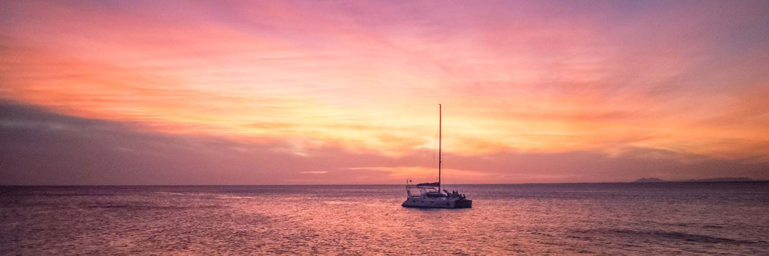Purple sunset with a sailboat by Meredith and Steve Schnoll